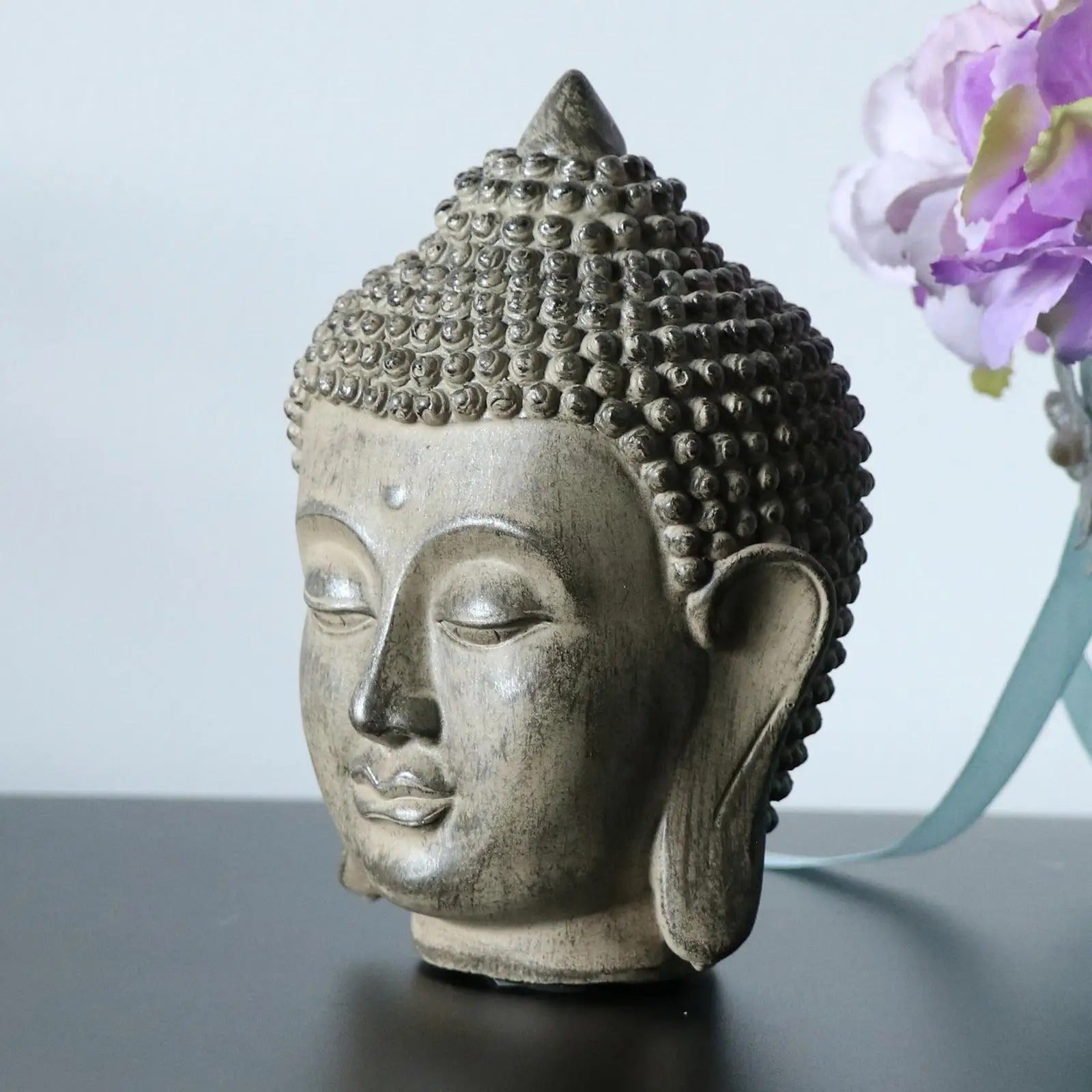 statue tete bouddha profil fleurs